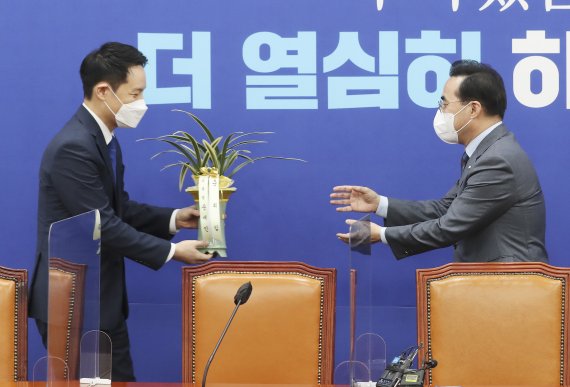 박홍근 더불어민주당 신임 원내대표가 25일 서울 여의도 국회 원내대표 회의실에서 김한규 대통령비서실 정무비서관에게 문재인 대통령의 축하난을 받고 있다. 2022.3.25/뉴스1 © News1 이동해 기자