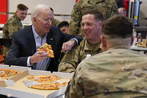 조 바이든 미국 대통령이 25일(현지시간) 폴란드 야시온카의 한 체육관에서 미 육군 82공정사단 장병들과 피자로 식사하고 있다.AP뉴시스