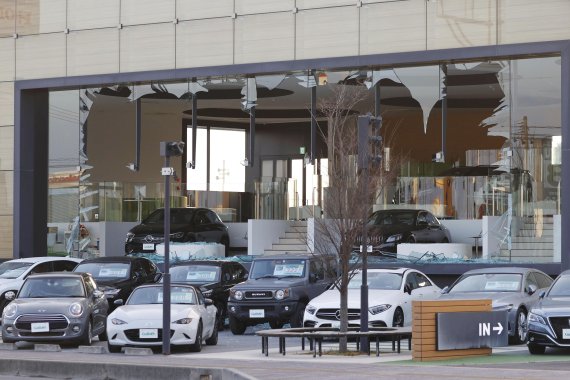 [고리야마=AP/뉴시스] 17일 일본 후쿠시마현 고리야마시에 위치한 한 자동차 판매점 유리창이 지진으로 인해 파손돼 있다. 2022.03.17.