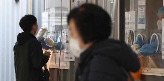 지난 25일 오전 서울 중구 서울역 임시선별검사소에서 한 시민이 PCR 검사를 받고 있다. 뉴시스 제공