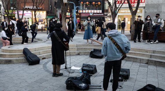 1일 서울 마포구 홍대 앞을 찾은 시민들이 버스킹 공연을 즐기고 있다. 마포구는 '버스킹 성지' 홍대 걷고싶은거리 야외공연장을 재개장한다고 3월30일 밝혔다. 이는 지난 2020년 11월 신종 코로나바이러스 감염증(코로나19) 사회적 거리두기 2단계 격상에 따라 야외공연장 사용이 중단된지 1년4개월만이다. 2022.4.1/뉴스1 © News1 유승관 기자