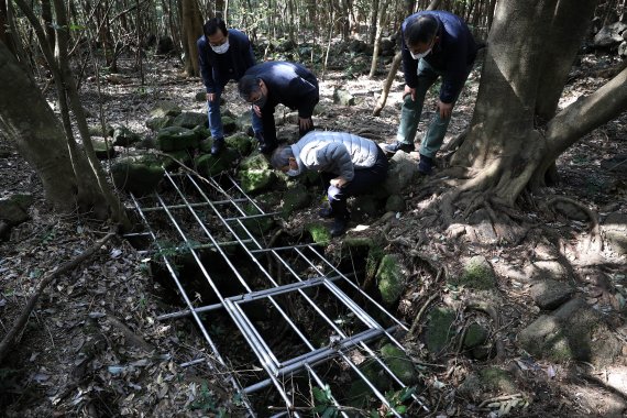 [제주=뉴시스] 백동현 기자 = 지난 29일 오후 제주시 조천읍 동백동산 산책로 옆에서 시민들이 도틀굴을 살펴보고 있다. 도틀굴은 4.3 사건 당시의 피신했던 흔적과 유품들이 발견된 유적 동굴이다. 2022.04.03. livertrent@newsis.com