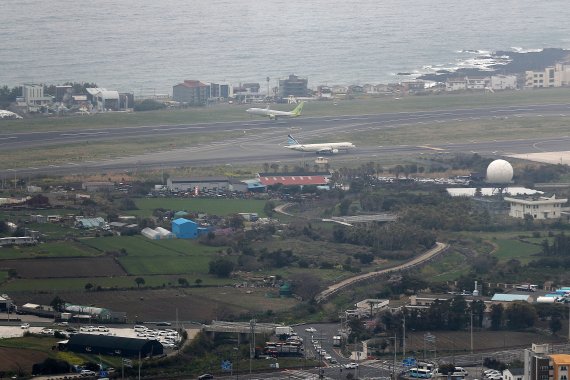 [제주=뉴시스] 백동현 기자 = 지난 31일 오후 제주공항 활주로에 비행기가 이동하고 있다. 현 제주공항 남북활주로 동북 측 지점과 서북 측 지점인 옛 정뜨르 비행장 인근에서는 4.3사건 관련 완전유해 261구와 유해 약 123구가 각각 발견됐다. 2022.04.03. livertrent@newsis.com