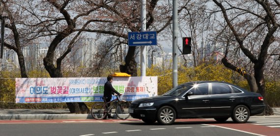 [서울=뉴시스] 고범준 기자 = 3일 서울 영등포구 윤중로 벚꽃길(여의서로) 거리에 보행로 개방 관련 현수막이 걸려 있다. 영등포구는 개화 시기가 늦어지면서 여의도 벚꽃길 개방 날짜를 오는 9일부터 17일까지 변경했다. 하루 전날인 4월8일 정오부터 4월18일 정오까지는 교통통제가 시행된다. 2022.04.03. bjko@newsis.com