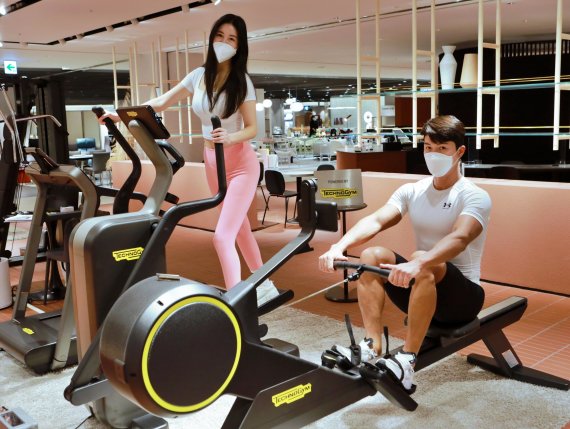 모델들이 서울 송파구에 위치한 롯데백화점 잠실점 10층 '테크노짐' 팝업에서 홈 피트니스 기구들을 소개하고 있다.