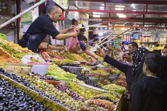 [카사블랑카=AP/뉴시스] 모로코 사람들이 3일(현지시간) 이슬람 성월 라마단 첫날 수도 카사블랑카의 시장에서 올리브 등 라마단 상품들을 구입하고 있다. 2022.04.04.