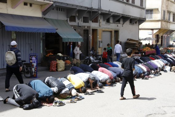 [카사블랑카=AP/뉴시스] 3일(현지시간) 이슬람 성월 라마단 첫날 모로코 카사블랑카에 있는 이슬람 사원 밖 거리에서 남성들이 정오 기도를 하고 있다. 2022.04.04.