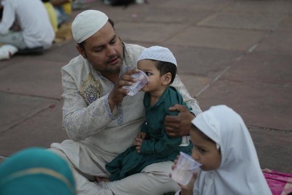 [뉴델리=AP/뉴시스] 3일(현지시간) 인도 뉴델리의 자마 마스지드 사원에서 한 남성이 라마단 첫날 금식을 마친 후 아들에게 물을 먹이고 있다. 2022.04.04.