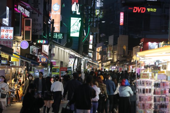 4일 오후 서울 마포구 홍대거리에서 시민들이 발걸음을 옮기고 있다. 중앙재난안전대책본부에 따르면 이날 0시부터 오는 17일까지 2주간 사적모임 가능 인원은 10명, 식당과 카페 등 다중이용시설 영업제한 시간은 밤 12시로 늘어난다. 행사나 집회 인원은 종전처럼 최대 299명까지로 유지된다. 정부는 위중증 환자·의료체계 여력 등이 안정적으로 유지된다면 2주 후에는 실내 마스크를 제외한 거리두기 해제도 가능하다는 입장이다. 2022.4.4/뉴스1 © News1 황기선 기자