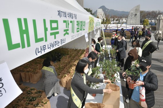 [서울=뉴시스] 정병혁 기자 = 식목일인 5일 오전 서울 종로구 세종로공원에서 열린 '내 나무 갖기 캠페인' 행사에서 시민들이 목수국, 서향(천리향) 등 나무를 받아가고 있다. (공동취재사진) 2022.04.05. photo@newsis.com