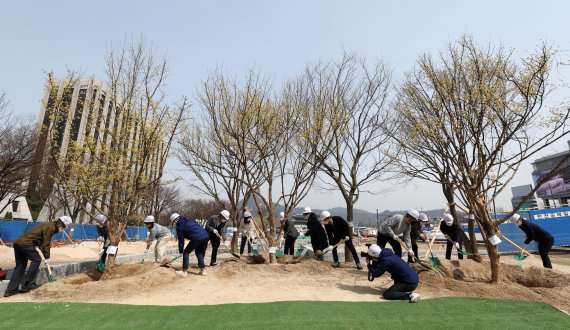 [서울=뉴시스] 정병혁 기자 = 오세훈 서울시장이 제77회 식목일을 맞은 5일 서울 종로구 세종로공원 앞에 조성 중인 광화문광장 사계정원에서 시민참여단 등 서울 각 지역 시민들과 함께 산수유 나무를 심고 있다. (공동취재사진) 2022.04.05. photo@newsis.com