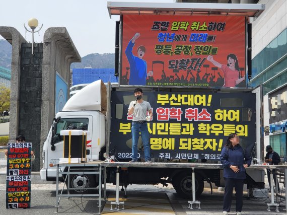 [부산=뉴시스] 이동민 기자 = 시민단체 '정의로운 사람들'이 5일 오후 부산 금정구 부산대 정문 앞에서 조민의 의학전문대학원 입학 취소를 촉구하는 시위를 벌이고 있다.<div id='ad_body2' class='ad_center'></div> 2022.04.05. eastsky@newsis.com