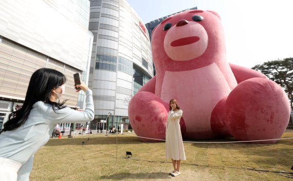 5일 서울 송파구 잠실 롯데월드타워 앞 잔디광장에 설치된 '벨리곰' 앞에서 시민들이 기념사진을 찍고 있다. '벨리곰'은 롯데홈쇼핑이 지난 2018년 MZ세대 직원을 대상으로 진행한 사내 벤처 프로그램에서 탄생한 캐릭터로 롯데월드타워 오픈 5주년을 맞이해 지난 1일부터 잔디광장에 15m 크기의 벨리곰을 전시하고 있다. 2022.4.5/뉴스1 © News1 박세연 기자