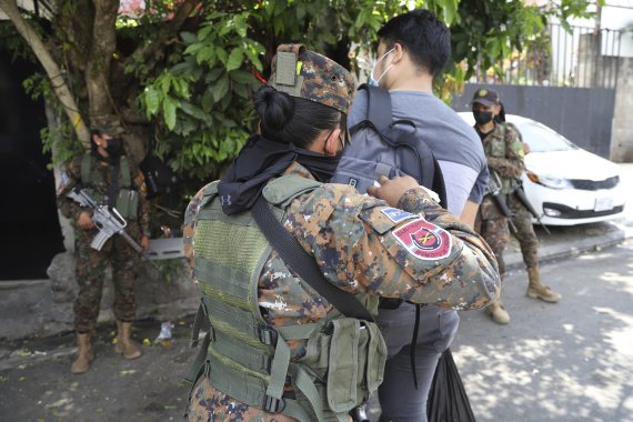 A soldiers searches the backpack of a local at the San Jose del Pino Community in Santa Tecla, El Salvador, Wednesday, April 6, 2022, during the government's unprecedented crackdown on gangs. El Salvador's congress, pushing further in the government's crackdown, has authorized prison sentences of 10