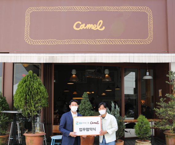 이기철 GS리테일 기획MD부문장(왼쪽)과 박강현 카멜커피 대표가 카멜커피 도산점 앞에서 기념촬영을 하고 있다.