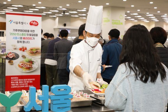 지난 8일 서울시청 구내식당에서 직원들이 신세계푸드의 대체육 ‘베러미트(Better Meat)’로 만들어진 샌드위치를 배식 받고 있다. 이날 행사는 신세계푸드와 서울시가 대체육을 통한 인류건강, 동물복지, 지구환경에 대한 사회적 가치를 공감하고 직원들에게 알리기 위해 진행됐다.