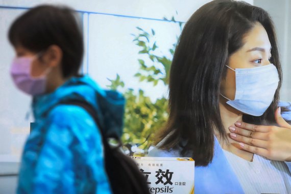 대만의 한 어린이가 마스크를 착용을 권고하는 홍보물 앞으로 마스크를 착용한 채 걸어가고 있다 . /사진=로이터뉴스1