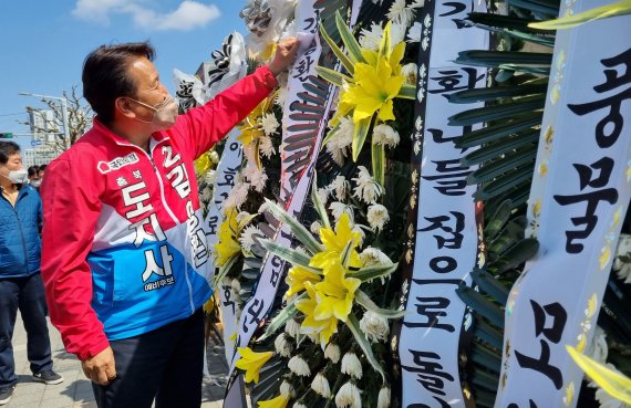 충북도지사 예비후보로 등록한 국민의힘 김영환 전 의원이 지난 11일 충북도청 앞에서 자신의 충북지사 출마를 반대하는 내용의 근조화환을 살펴보고 있다./뉴스1 © News1 김용빈 기자