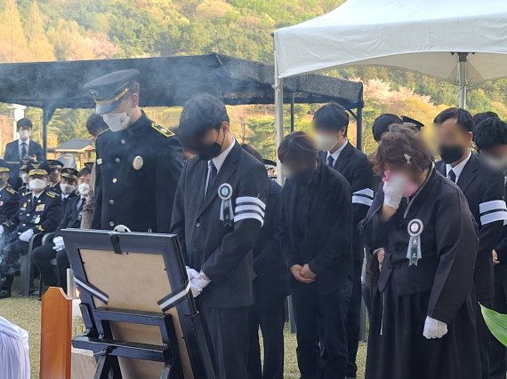 12일 국립 대전현충원에서 엄수된 헬기 추락사고 순직 항공대원들에 대한 안장식에서 유족들이 마지막 인사를 하며 눈물을 훔치고 있다. © 뉴스1