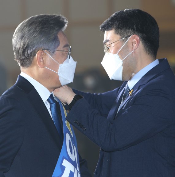 [원주=뉴시스] 김경목 기자 = 12일 오후 이재명 더불어민주당 대선 경선 후보의 수행비서인 김남국 의원이 강원도 원주시 오크밸리 리조트 컨벤션홀에서 열린 제20대 대통령선거 후보자 선출을 위한 합동연설회에 행사장에서 어깨띠를 걸어주고 있다. 2021.09.12. photo31@newsis.com