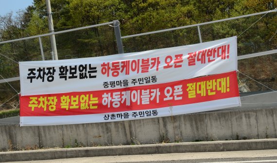 하동 금오산 케이블카 인근 마을 주민들이 주차장 확보 없는 케이블카 개통을 절대 반대하는 현수막을 내걸었다(독자제공). 2022.4.13 © 뉴스1