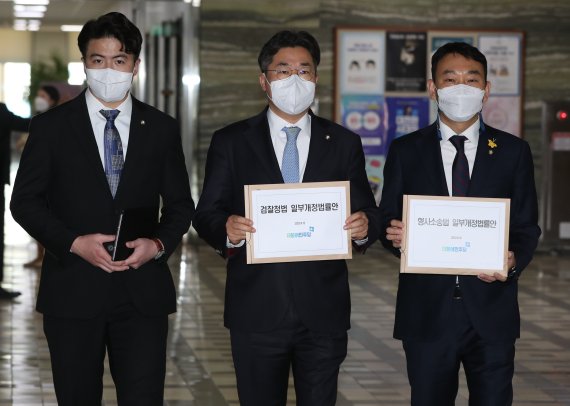 더불어민주당 오영환(왼쪽부터), 박찬대, 김용민 의원이 15일 서울 여의도 국회 의안과에 검찰청법 일부개정법률안과 형사소송법 일부개정법률안을 제출하고 있다. 2022.5.15/뉴스1 © News1 허경 기자