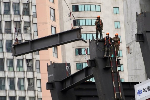 Workers watch as a crane lifts a structure at a construction site in Shanghai, China January 14, 2022. REUTERS/Aly Song/File Photo /REUTERS/뉴스1 /사진=뉴스1 외신화상