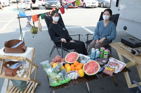 18일 서울시 서초구 농협 하나로마트 양재점에서 모델들이 캠핑 음식과 함께 캠핑카 대여서비스를 소개하고 있다. 농협유통 제공.