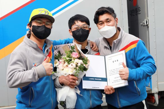 택배기사 길현철(가운데)씨가 동료들과 함께 시상식 이후에 기념사진을 찍고 있다.(CJ대한통운 제공)© 뉴스1