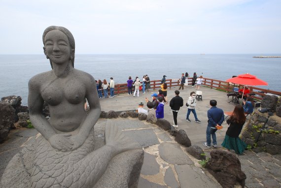 [제주=뉴시스] 우장호 기자 = 사회적 거리두기 조치가 전면 해제된 18일 오후 제주 시내 대표 관광지인 용두암을 찾은 관광객들이 사진을 찍으며 즐거운 시간을 보내고 있다. 2022.04.18. woo1223@newsis.com