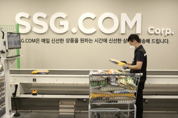 SSG닷컴의 PP센터에서 작업자가 자동화 소터에 상품을 투입하는 모습(SSG닷컴 제공)© 뉴스1