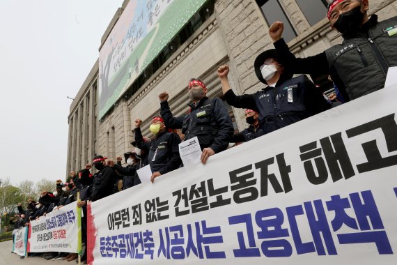 [서울=뉴시스] 김병문 기자 = 민주노총 전국건설노동조합 서울건설지부 조합원들이 18일 오전 서울 중구 서울시청 앞에서 열린 '둔촌주공재건축 공사중단 사태 현장 건설노동자 고용대책 촉구 긴급 기자회견'에서 구호를 외치고 있다. 2022.04.18. dadazon@newsis.com