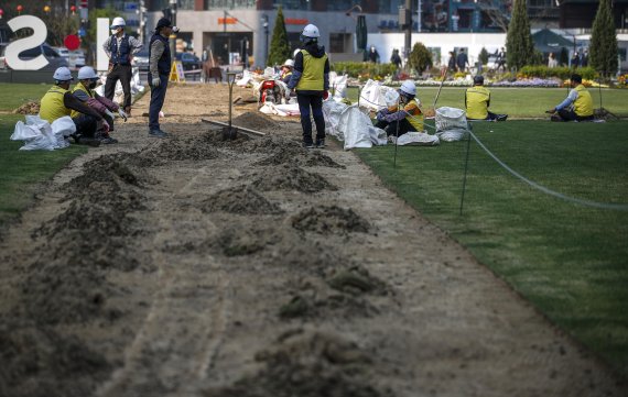 [서울=뉴시스] 정병혁 기자 = 19일 오전 서울 중구 서울광장에서 작업자들이 잔디 보수 작업을 하고 있다. 2022.04.19. jhope@newsis.com