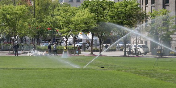 [서울=뉴시스] 이영환 기자 = 20일 오후 서울 중구 서울광장에 식재된 잔디에 관계자들이 물을 주고 있다. 서울시는 코로나19 팬데믹 기간 동안 중지됐던 서울광장 야외행사를 2년만에 재개한다. '책 읽는 서울광장'은 오는 23일 세계 책의 날을 시작으로 10월 말까지 매주 금~토요일 오전 11시부터 오후 4시까지 진행된다. 2022.04.20. 20hwan@newsis.com