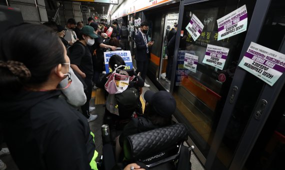 [서울=뉴시스] 이영환 기자 = 전국장애인차별철폐연대(전장연) 회원들이 21일 서울 종로구 지하철3호선 경복궁역에서 '출근길 지하철 타기' 시위를 하고 있다. 전장연에 따르면 시위는 이날 오전 7시부터 서울 지하철 3호선 경복궁역, 2호선 시청역, 5호선 광화문역 등 3곳에서 동시 진행된다. 2022.04.21. 20hwan@newsis.com