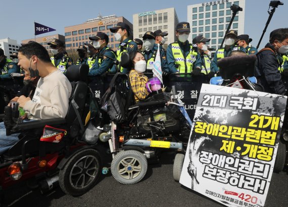 20일 오후 서울 영등포구 여의도 국회 인근에서 장애인차별철폐의 날 '420 장애인차별철폐 투쟁결의대회'에서 전국장애인차별철폐연대(전장연) 회원들이 경찰과 대치 하고 있다. 2022.4.20/뉴스1 © News1 송원영 기자