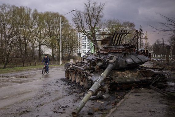 [체르니히우=AP/뉴시스] 21일(현지시간) 우크라이나 체르니히우에서 자전거를 탄 한 주민이 파괴된 러시아 전차 옆을 지나고 있다. 2022.04.22. /사진=뉴시스
