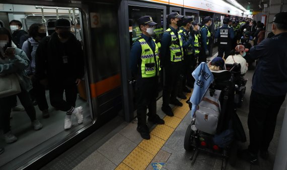 [서울=뉴시스] 이영환 기자 = 전국장애인차별철폐연대(전장연) 회원들이 21일 서울 종로구 지하철3호선 경복궁역에서 '출근길 지하철 타기' 시위를 하고 있다. 전장연에 따르면 시위는 이날 오전 7시부터 서울 지하철 3호선 경복궁역, 2호선 시청역, 5호선 광화문역 등 3곳에서 동시 진행된다. 2022.04.21. 20hwan@newsis.com