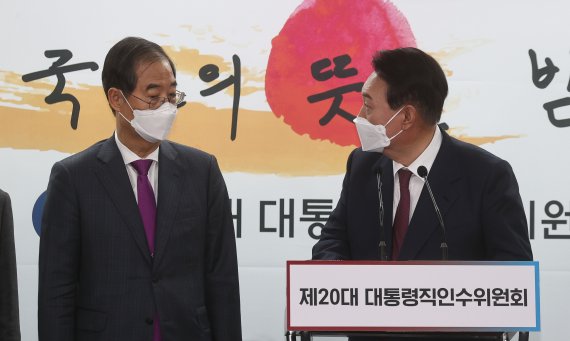 [서울=뉴시스] 인수위사진기자단 = 윤석열 대통령 당선인이 13일 서울 종로구 통의동 인수위 브리핑룸에서 열린 2차 내각 발표에서 한덕수 국무총리 후보자와 대화를 나누고 있다. 2022.04.13. photo@newsis.com