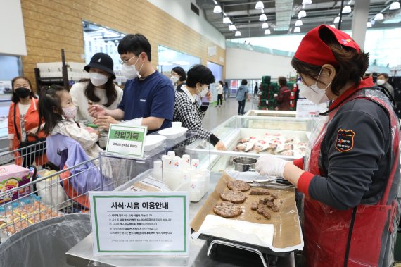 실내 다중이용시설 취식이 시작된 25일 오전 경기 수원시의 한 대형마트 시식코너에서 시민들이 음식을 시식하고 있다. 2022.4.25/뉴스1 © News1 김영운 기자