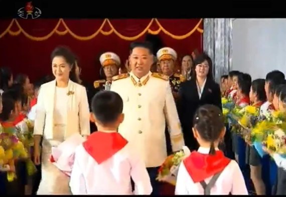김정은 북한 노동당 총비서가 주석단에서 화동의 꽃을 받을 때 의문의 여성(오른쪽)이 수행을 하고 있다. (조선중앙TV 갈무리)/사진=뉴스1