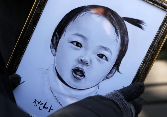 16개월 여아 '정인이'의 입양부모 공판이 열린 지난해 3월3일 서울 양천구 서울남부지법 앞에서 한 시민이 정인이 초상화를 바라보고 있다. /사진=뉴시스