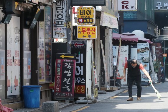 17일 서울 종로구 먹자골목에서 한 업주가 가게 앞을 청소하고 있다. 2022.4.17/뉴스1 © News1 민경석 기자