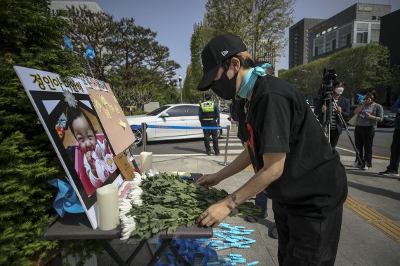 [서울=뉴시스] 정병혁 기자 = 입양한 16개월 여아 정인이를 학대 끝에 숨지게 한 혐의를 받는 양모의 대법원 선고를 앞둔 28일 오전 서울 서초구 대법원 앞에서 대한아동학대방지협회 관계자가 국화를 놓고 있다. 2022.04.28. jhope@newsis.com