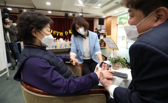 [서울=뉴시스] 홍효식 기자 = 가정의 달을 맞아 요양병원·시설의 한시적 접촉면회가 허용된 30일 오전 서울 성동구 시립동부노인전문요양센터에서 박영순(72세) 어르신이 아들과 딸을 만나 대화를 나누고 있다. 정부는 지난해 11월 18일부터 비접촉 면회만 허용해 왔지만 최근 확진자 발생 감소 추세와 접촉면회 수요를 고려해 이날부터 다음달 22일까지 3주간 한시적으로 변경했다. 2022.04.30. yesphoto@newsis.com