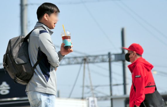 [광주=뉴시스] 이영주 기자 = 실외 마스크 착용 의무화가 해제된 2일 오전 광주 광산구 광주송정역 앞 광장에서 한 남성이 마스크를 벗은 채 음료수를 마시고 있다. 2022.05.02. leeyj2578@newsis.com