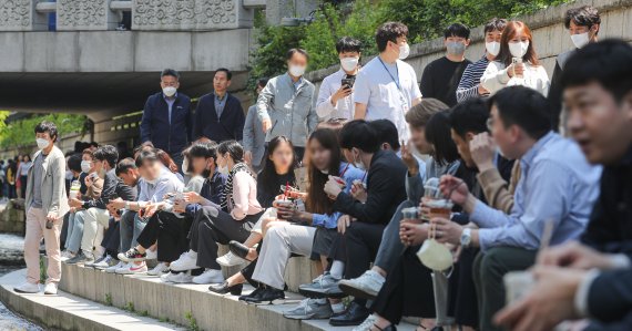 [서울=뉴시스] 권창회 기자 = 실외 마스크 의무화 해제 첫 날인 2일 오후 서울 중구 청계천에서 직장인들이 점심시간을 맞아 마스크를 벗고 휴식을 취하고 있다. 2022.05.02. kch0523@newsis.com