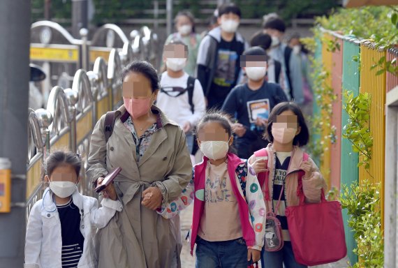 [광주=뉴시스] 류형근 기자 = 실외에서 마스크를 착용하지 않아도 되는 2일 오전 광주 남구 한 초등학교에서 학생들이 마스크를 착용한 채 등교하고 있다. 2022.05.02. hgryu77@newsis.com