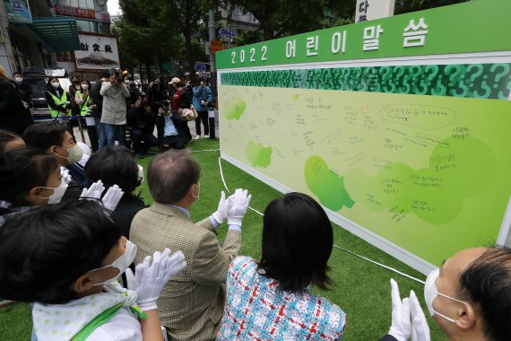 [서울=뉴시스] 백동현 기자 = 지난 2일 오전 서울 중구 초록우산 어린이재단 앞 누리마당에서 열린 '어린이날 100주년 기념 2022 어린이말씀 선포식'에서 주요 참석자들이 현판에 적힌 내용을 살펴보고 있다. 2022.05.02. livertrent@newsis.com