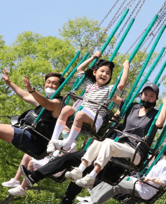 100번째 어린이날인 5일 서울 송파구 롯데월드에서 한 어린이가 밝은 표정으로 회전그네 놀이기구를 타고 있다. 2022.5.5/뉴스1 © News1 장수영 기자